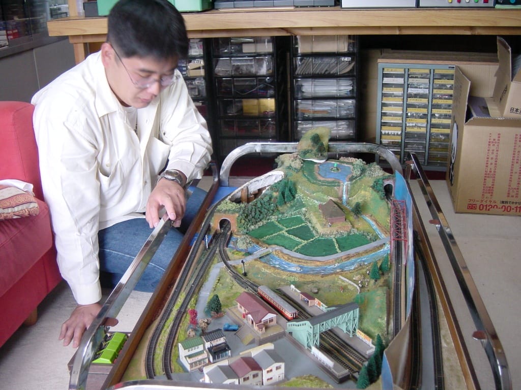 鉄道模型ジオラマを操作する教え子