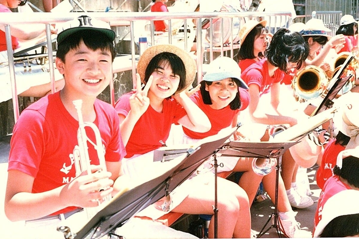 応援中、カメラに向かって笑顔でピースサインをする吹奏楽部員たち。