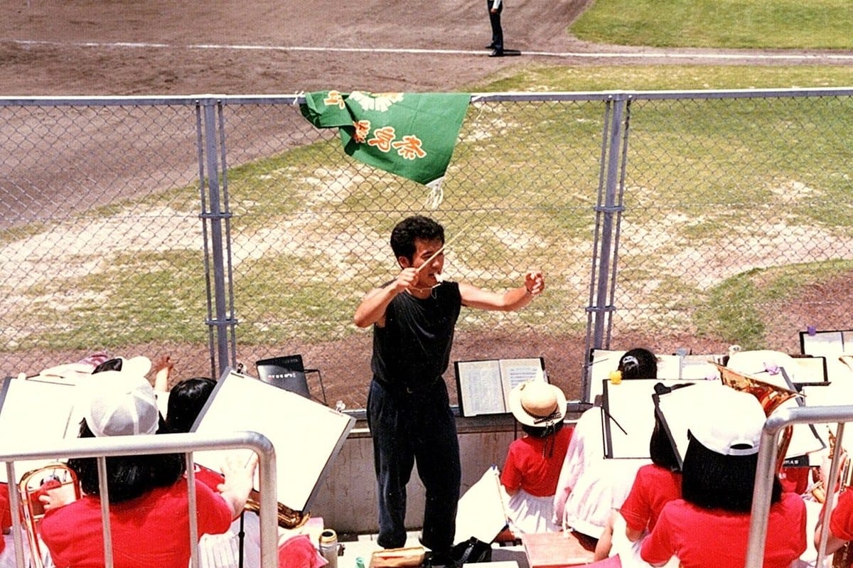 OBがアルプス席で全身でタクトを振り、吹奏楽部をリードしている。