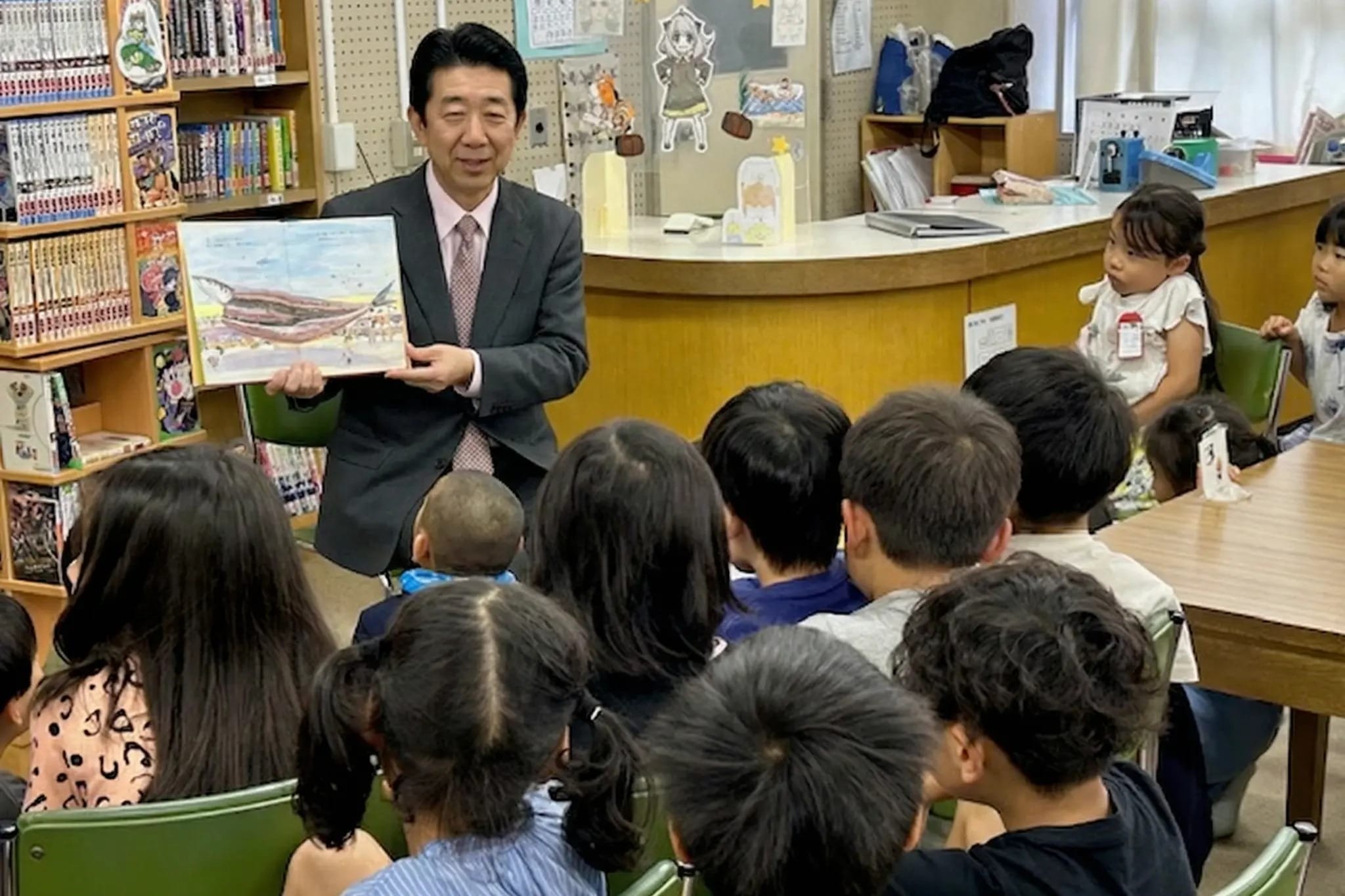 斑鳩東小学校の図書室で子どもたちに絵本を読み聞かせる加藤凌校長